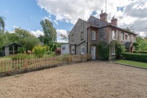 an old brick house with a wooden fence at Duck Cottage - Grade II Listed cottage, village location, nr Holt in Letheringsett