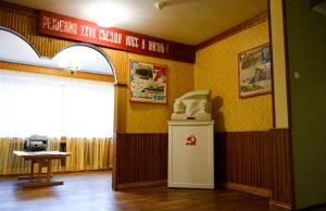 PyramidenにあるHotel Pyramidenの冷蔵庫付きの客室で、壁に看板が付いています。