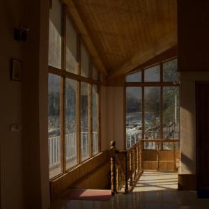 Pokój z dużymi oknami i schodami w domu w obiekcie Himachal Villa 3 BHK w mieście Kullu