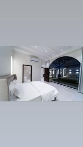 a bedroom with a bed and a large window at منتجع ريتال in Dhahran