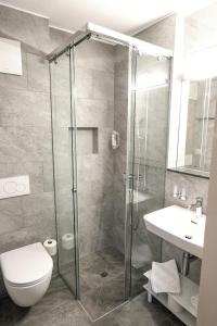 a bathroom with a shower and a toilet and a sink at b&b River Inn in St. Moritz