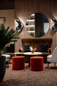 uma sala de estar com um sofá, uma mesa e um espelho em Quality Hotel Saga em Tromsø