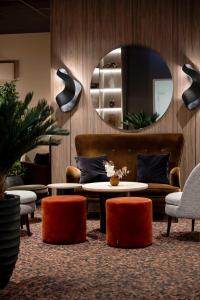 a living room with a couch and a table and a mirror at Quality Hotel Saga in Troms&oslash;