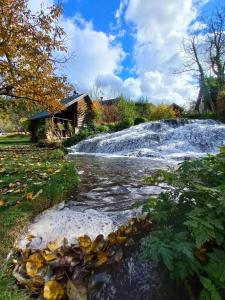 a waterfall in front of a house in front of a river at Janjske otoke - smještaj na selu (Milorad Piljić) in Šipovo