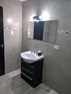 een badkamer met een wastafel en een spiegel bij Casa Lidia in Chascomús