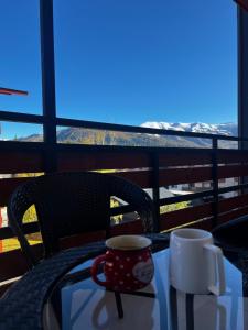a table with two coffee cups on a balcony at BAKURIANI INN 439 in Bakuriani