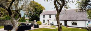 una casa blanca con techo negro en Celtic Haven en Tenby