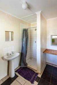 y baño con lavabo y ducha. en African Sunsets (Bophirimo Self-Catering Guest House), en Kasane