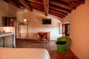 ProssediにあるLocanda Perseiのキッチン、テーブル、緑の椅子が備わる客室です。