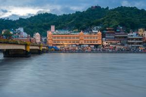 un pont sur une masse d'eau avec une ville dans l'établissement Ganga Lahari by Leisure Hotels, à Haridwar