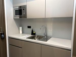 eine Küche mit einer Spüle und einer Mikrowelle in der Unterkunft ARUS Hotels in Hamburg
