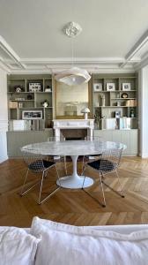 een keuken met een tafel en stoelen in een kamer bij Grand appartement Haussmannien à 12 min de Paris - Proche Stade de France - Jeux Olympiques 2024 in Enghien-les-Bains