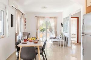 a kitchen and living room with a table and chairs at Villa Katherina - Tsambika View in Archangelos