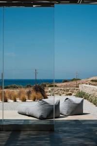 ein Bett mit Kissen auf dem Boden neben dem Meer in der Unterkunft Luxury Cycladic Villa with Seaview and MiniPool in Naxos Chora