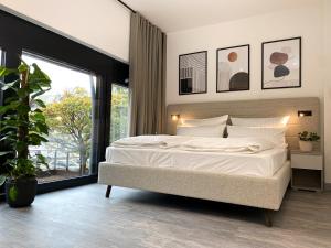 ein Schlafzimmer mit einem großen Bett und einem großen Fenster in der Unterkunft ARUS Hotels in Hamburg