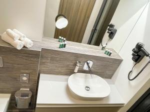 a bathroom with a sink and a mirror at ARUS Hotels in Hamburg