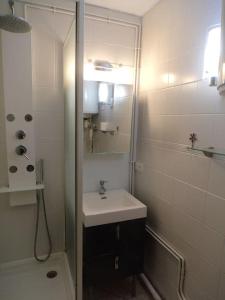 a white bathroom with a sink and a shower at T3/ 500 M du marché de Noël /200 M de la plage in Le Barcarès