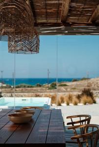 einem Holztisch mit zwei Stühlen und einer Schüssel darüber in der Unterkunft Luxury Cycladic Villa with Seaview and MiniPool in Naxos Chora