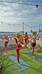 un grupo de personas haciendo yoga en un crucero en Good Wave Surf House en Tamraght Ou Fella