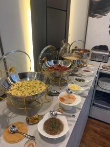 a buffet with many bowls of food on a table at Regency Inn Hotel Oman in Muscat