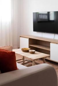 ein Wohnzimmer mit einem TV und einem Couchtisch in der Unterkunft Apartamento Jaira in Playa Honda