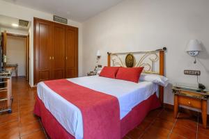 a bedroom with a large bed with red pillows on it at Hotel H28 Camas in Camas