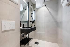 baño con lavabo negro y espejo en Quality Hotel Saga, en Tromsø