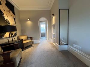 ein Wohnzimmer mit einem Sofa und einem Stuhl in der Unterkunft Star London Warwick Mansions 3-Bed Haven in London