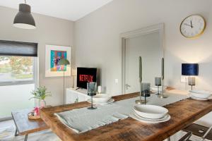 a dining room with a table and a clock on the wall at Brand New 1-Bed Flat With Free Parking in Nottingham