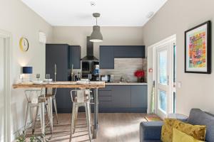 a kitchen and living room with blue cabinets and a counter at Brand New 1-Bed Flat With Free Parking in Nottingham