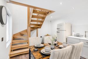 a kitchen with a wooden table and chairs and a staircase at Luxury 2 Bed City Centre with Parking in Norwich