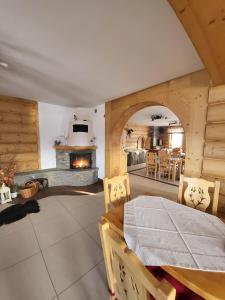 a dining room with a table and a fireplace at Jedla Miejsce Gościnne in Bukowina Tatrzańska