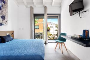 1 dormitorio con cama azul, escritorio y ventana en Double D House, en Olbia