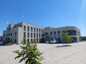 un grand bâtiment avec un arbre en face dans l'établissement Amtsgerichts Blick, à Oppenheim