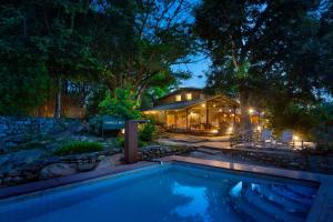 马西尼古蒂Jungle Hut Resort的房屋前设有游泳池的房屋