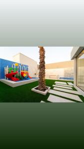 a playground with a palm tree in a building at منتجع ريتال in Dhahran