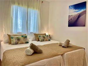 two beds in a room with a window at Los Balandros 106 by SunHousesCanarias in San Agustin