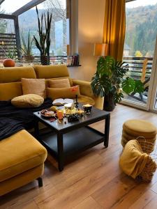 a living room with a couch and a coffee table at Apartamenty i Las in Brenna