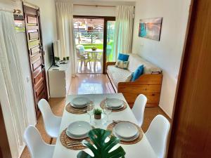 una mesa blanca y sillas en la sala de estar. en Los Balandros 106 by SunHousesCanarias en San Agustin