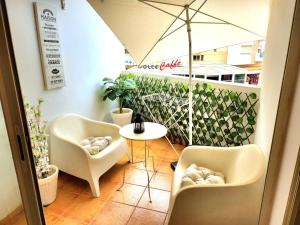 a room with two chairs and a table and an umbrella at La perle in Nouaceur