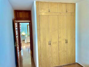 a room with a large wooden cabinet next to a hallway at Los Balandros 106 by SunHousesCanarias in San Agustin