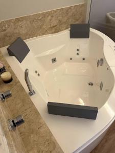 a white bath tub sitting in a bathroom at Condall Palace Hotel in Nova Prata