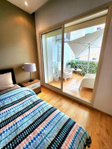 - une chambre avec un lit et un balcon avec un parasol dans l'établissement La perle, à Nouaceur