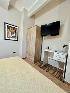 a room with a bed and a desk and a tv at Tutti i Comfort Giuliano's Apartment in Messina