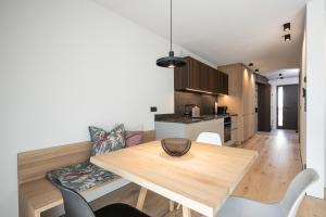 una cucina e una sala da pranzo con tavolo e sedie in legno di Luis Chalet a Brunico