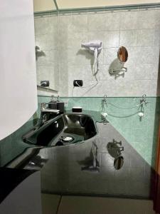 bagno con lavandino e asciugacapelli. di Tutti i Comfort Giuliano's Apartment a Messina