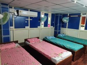 three beds in a room with blue walls at Rajeswari Ac Dormitory For Indian males only in Port Blair