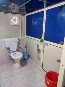 a small bathroom with a toilet and a shower at Rajeswari Ac Dormitory For Indian males only in Port Blair