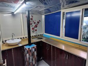 a bathroom with a sink and a counter withwindows at Rajeswari Ac Dormitory For Indian males only in Port Blair
