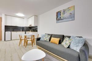 a living room with a couch and a table at Flatbook - City Center SPA Apartments Waterlane Island in Gdańsk